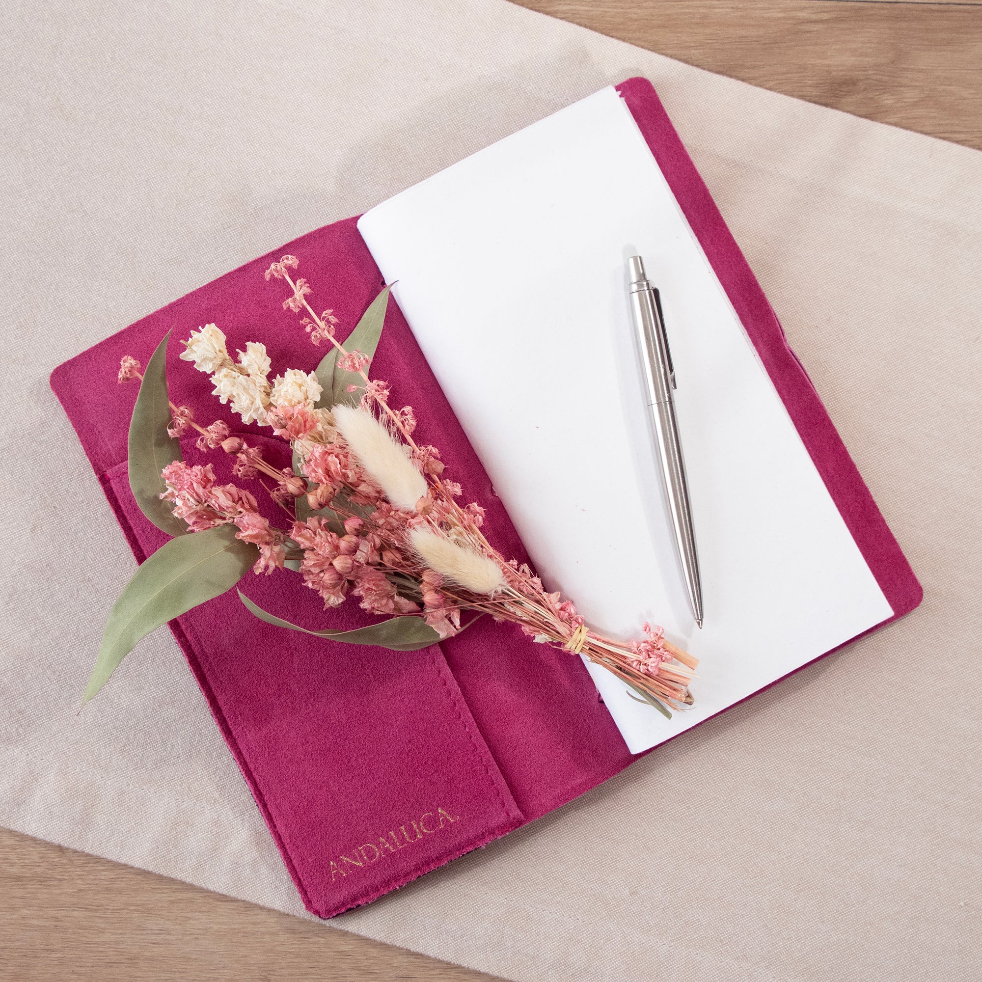 Mini bouquet of pink and white flowers with green leaves and bunny tail stems.