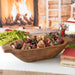 Pomegranate Pine Potpourri displayed in a wooden bowl on a table decorated for the winter holidays.