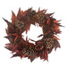 Wreath with pinecones and red leaves on a white background