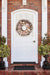 Wreath made from brown starfish, clamshells, and white conch shells on brown twig wreath base.