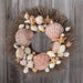 Wreath made from brown starfish, clamshells, and white conch shells on brown twig wreath base.