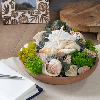 Seashell Medley & Moss Bowl Filler displayed in a bowl on a table.