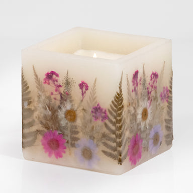 Pressed flower filled wax hurricane with pink flowers.