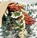 Dried bouquet of protea, statice flowers, and preserved baby eucalyptus.