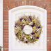 Bright wildflower wreath with yellow, purple, pink, white, and green.