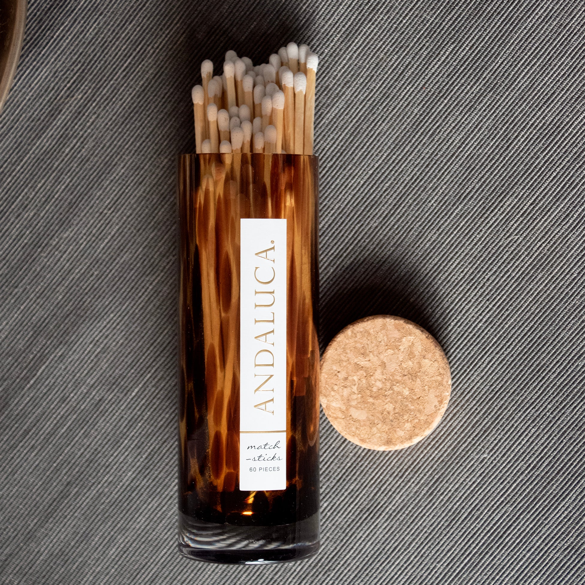 Tortoiseshell matchstick box with 'Andaluca' branding on a textured gray background