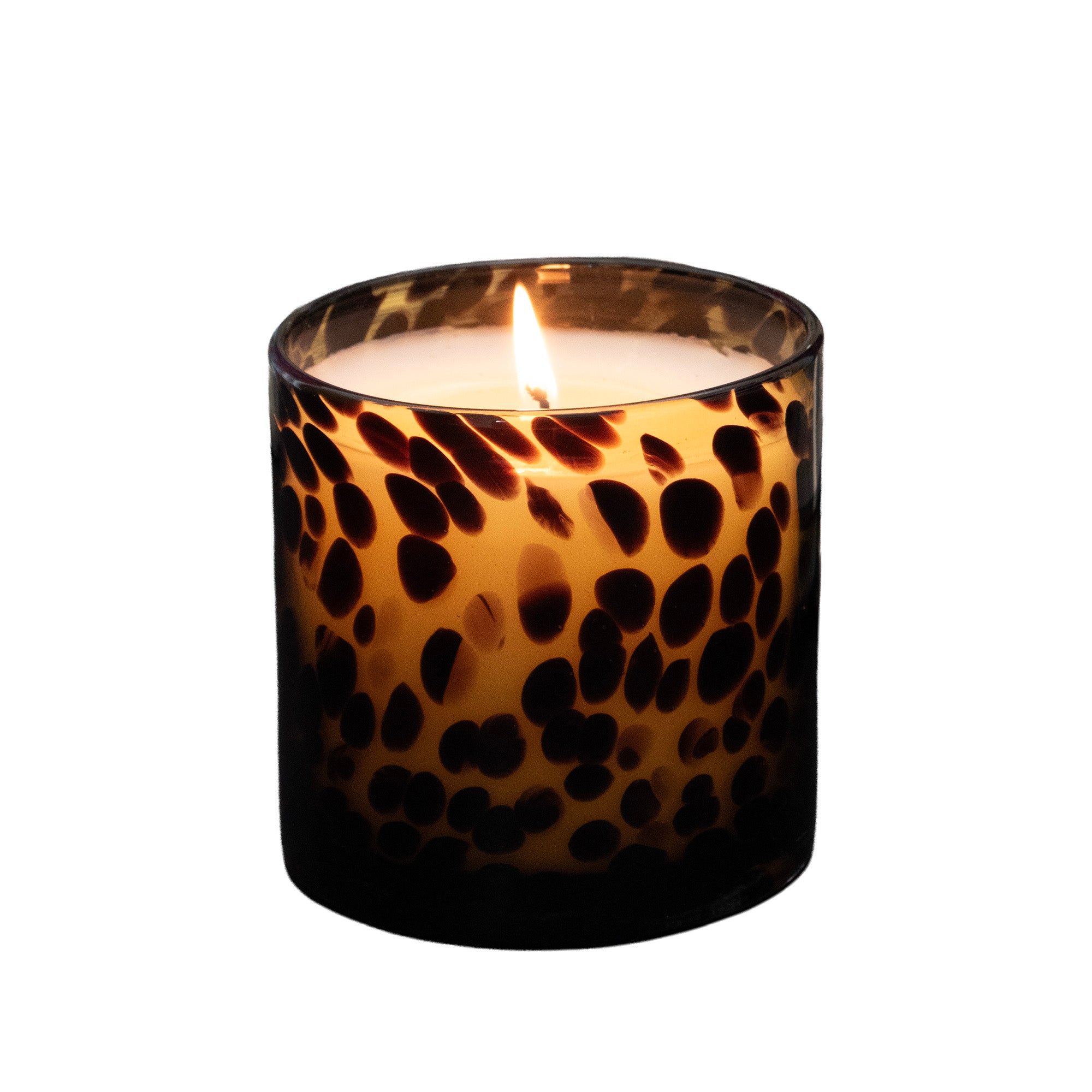 A lit Tortoise Glass candle, set against a solid white background.
