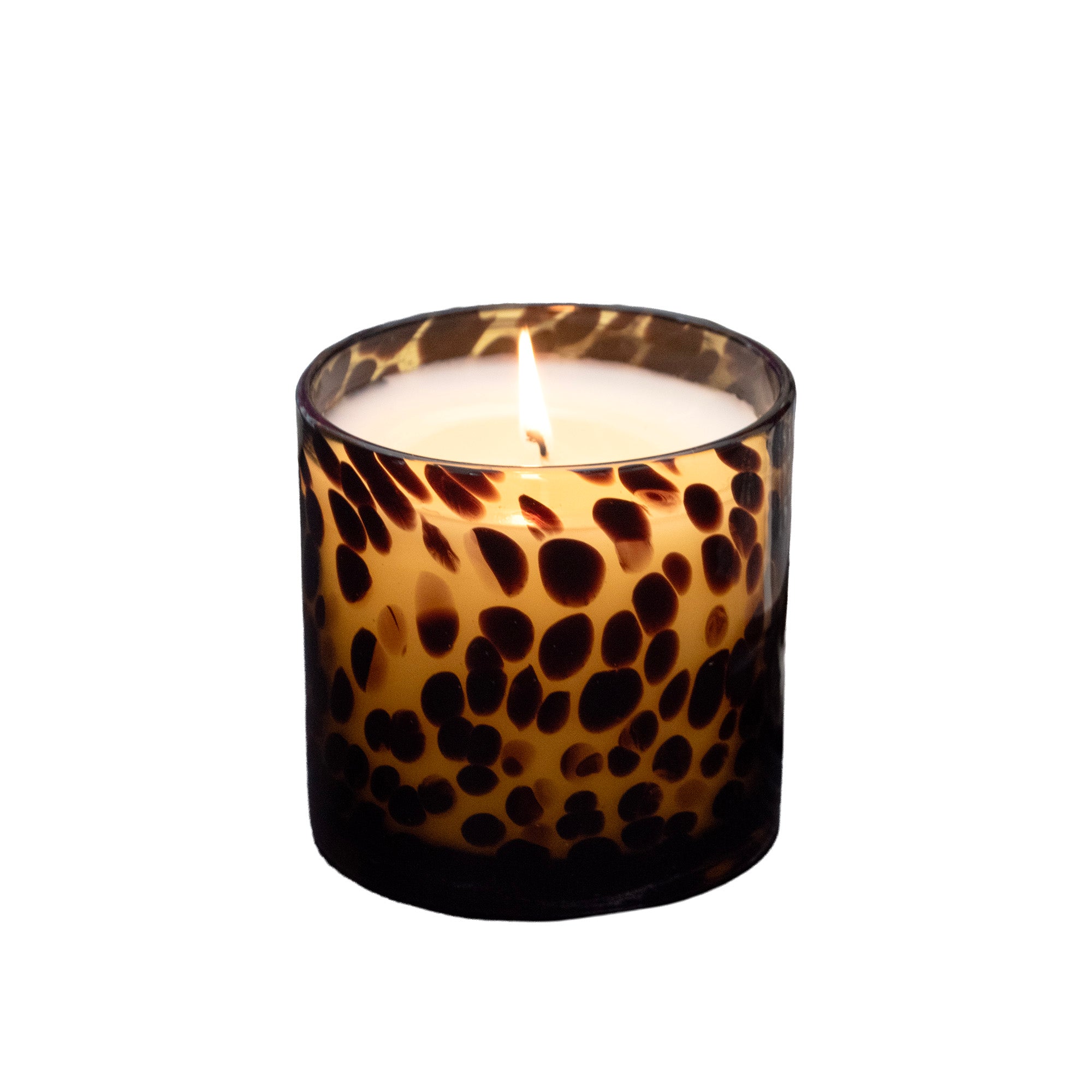 A lit candle in a cylindrical glass holder with a dark brown and amber leopard print pattern, set against a plain white background.