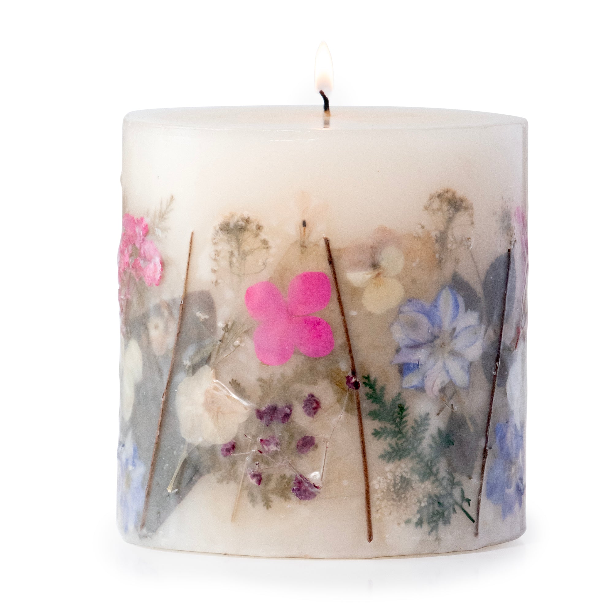 Ivory pillar candle with delicate pressed pink and purple flowers and green leaves decorating the outside of the candle.