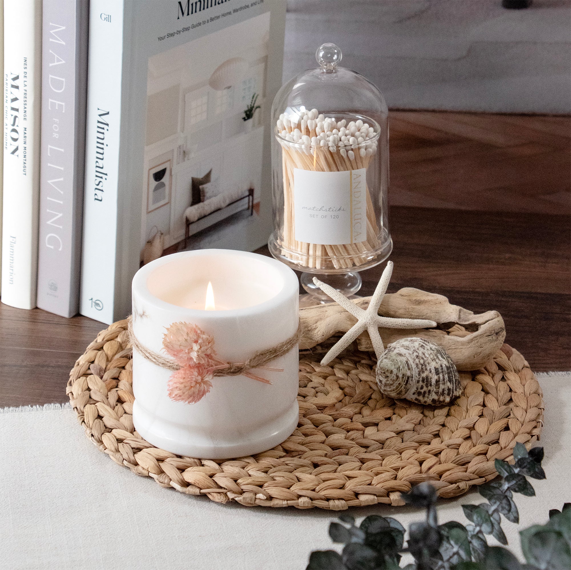 Lit white marble candle cup. Product shot, on a table.