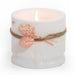 Lit white marble candle cup with flower tie. Product shot, on white background.