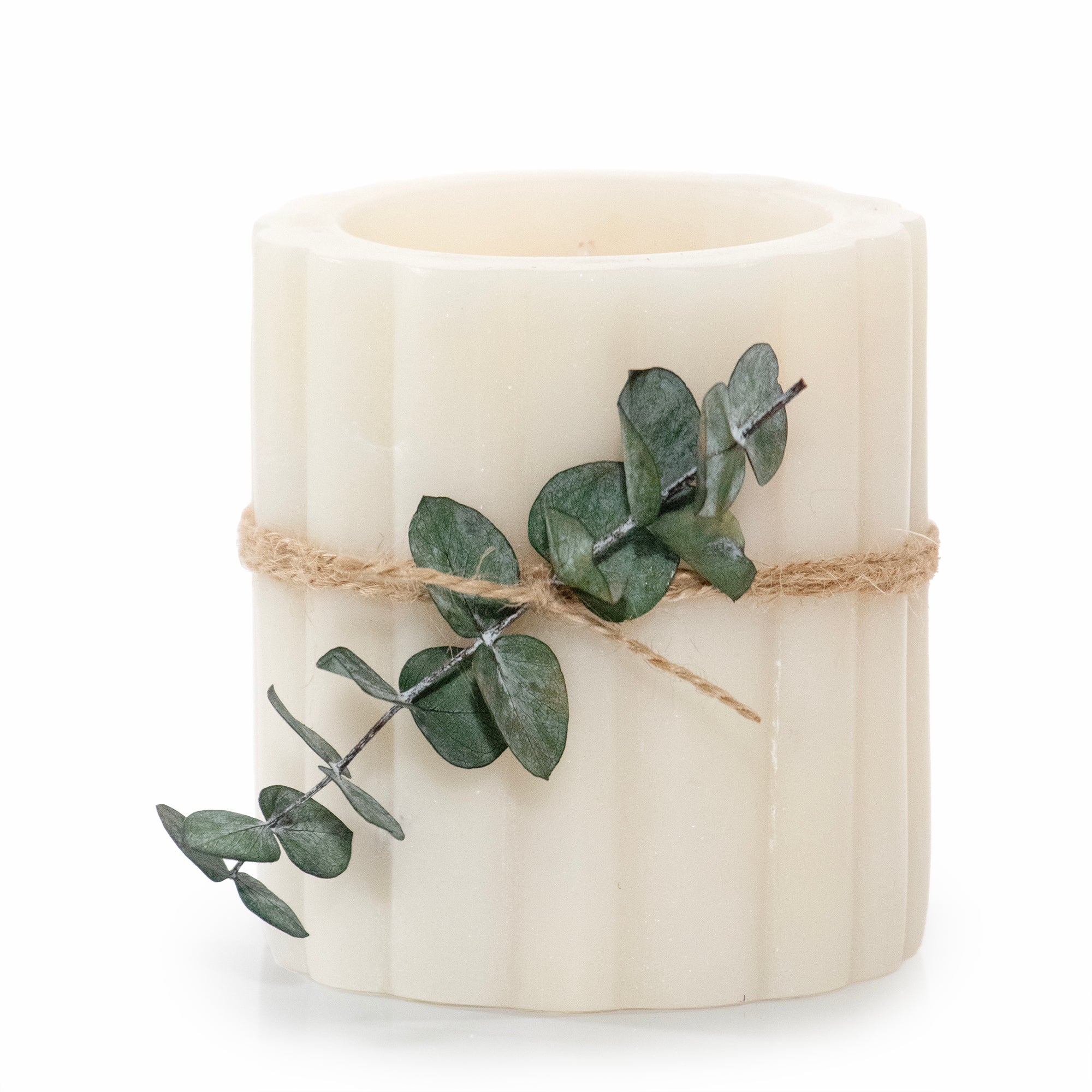 White candle with eucalyptus branch tied with twine on a white background