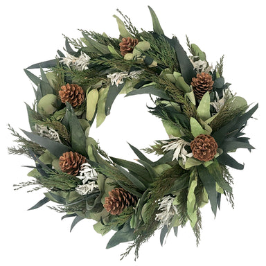 Winter Sage Haoliday wreath, filled with dried sage, willow eucalyptus leaves and accentuated with pinecones, on a white background.