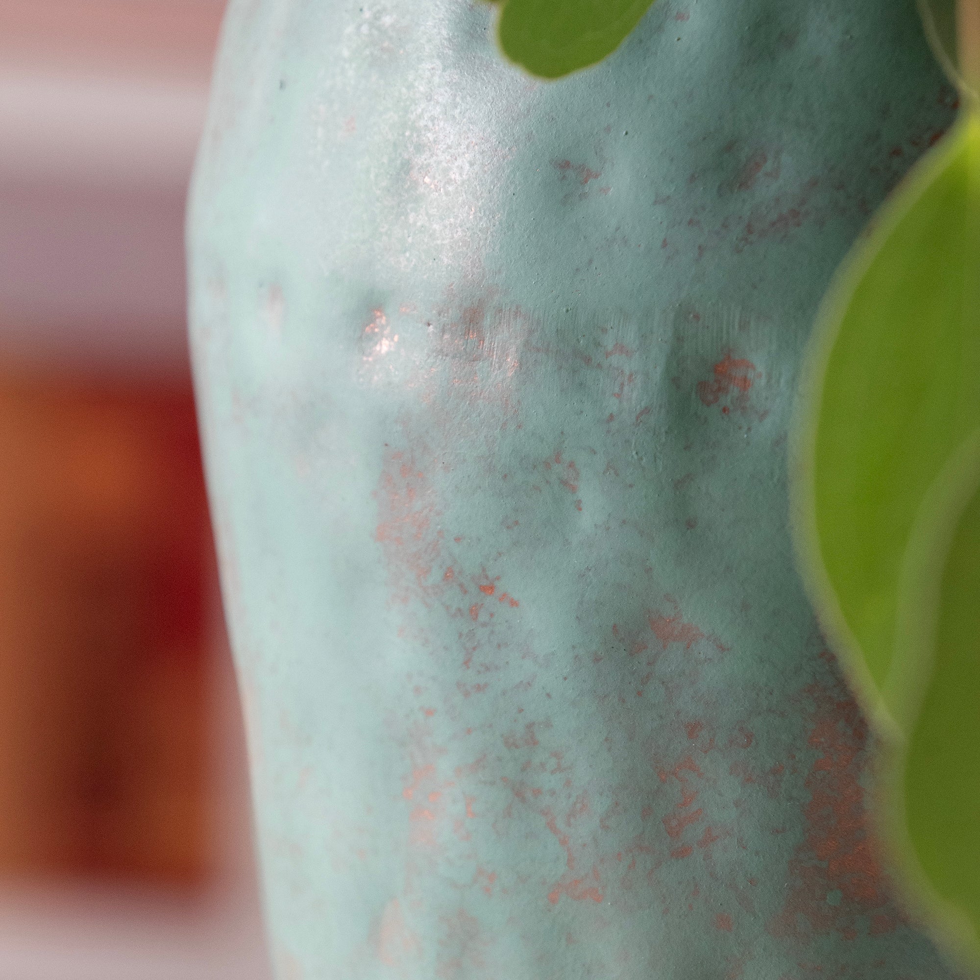 close up, metal vase in room setting with fresh eucalyptus.