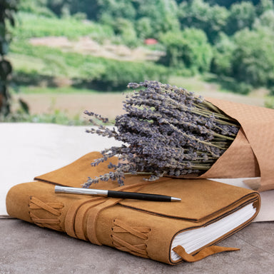 Cognac color Large Suede Leather Journal w/ Organic Cotton Paper Large. Showing it closed with a writing pen on top of it.